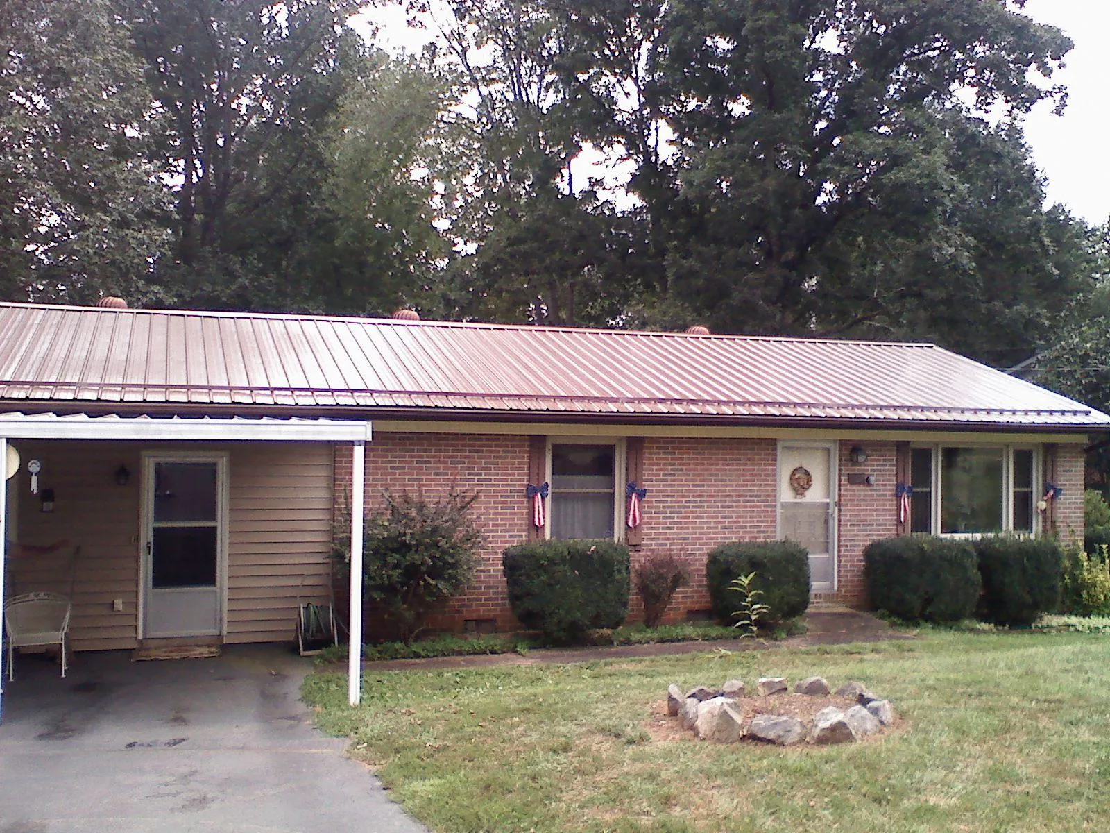 Bronze metal roof and carport on a brick ranch home — Roof Repair work by our crew in Mount Olive